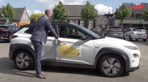 Wethouder opent de portier van zijn auto om de deelnemer uit te laten stappen