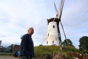 John de Jongh met de molen op achtergrond