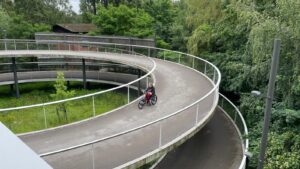 Fietspad in de vorm van een spiraal waar Jenny naar beneden gaat in haar handbike