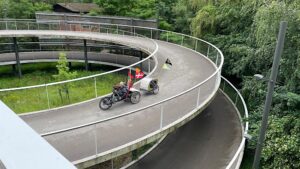 Fietspad in de vorm van een spiraal waar Astrid naar beneden gaat in haar handbike