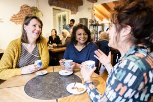 3 vrouwen on een ronde tafel voeren zichtbaar een leuk gesprek