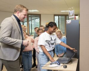 de wethouder en een kind kijken naar een laptop